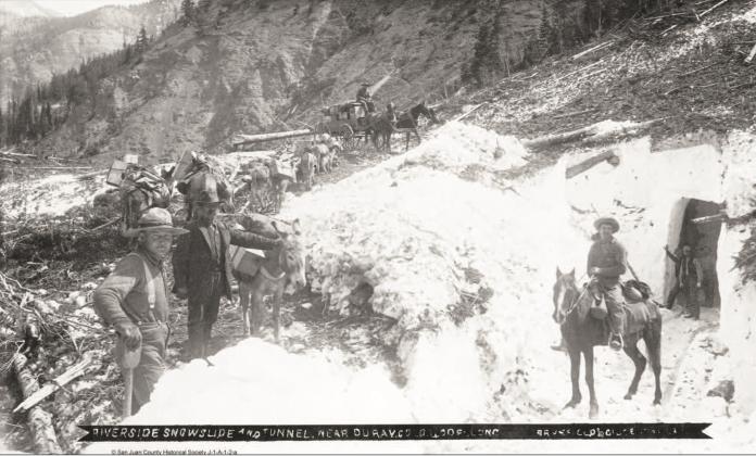 The Riverside Slide on Red Mountain Pass, with a snow tunnel on the right, and horses on top pulling a wagon, along with a pack string of burros to the left in an undated photo.