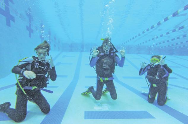 Kat Barbe's first Silverton class (left to right Paton Edwards, Whitney Pratz, Belen Roof) gives the OK symbol underwater at the Montrose Rec Center. Divers learn many hand signals to communicate beneath the surface. Photo Credit Kat Barbe